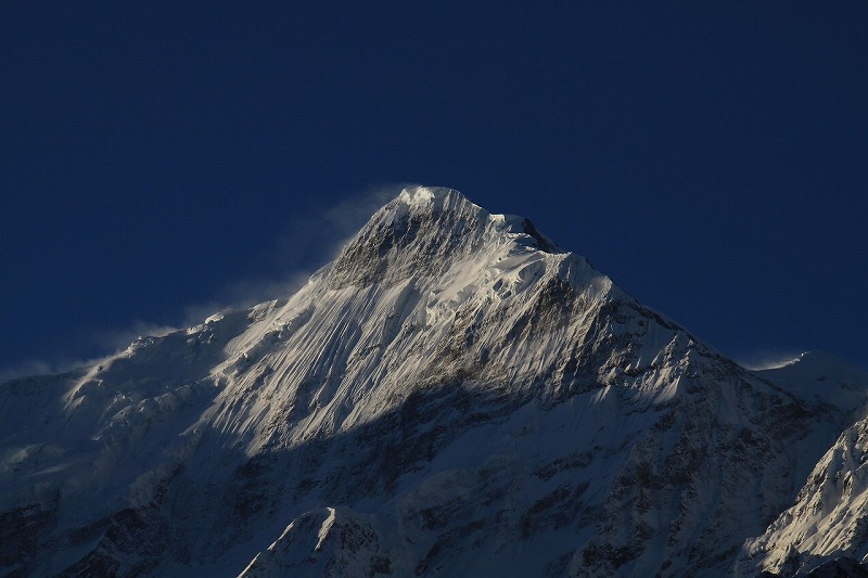 頂上が吹雪いているネパールのヒマラヤのニルギリ山です。
